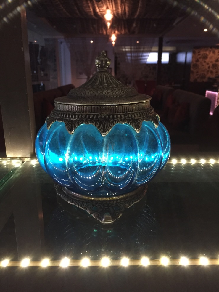 The blue glass pot kept on a glass shelf